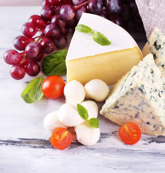 Formaggio saporito diverso, su tavolo di legno — Foto Stock