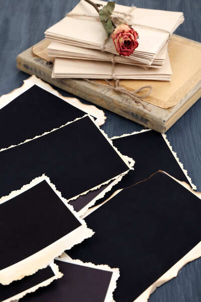 Blank old photos, photo album and dried flower, on color wooden background