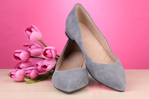 Beautiful grey female shoes and flowers on pink background — Stock Photo, Image