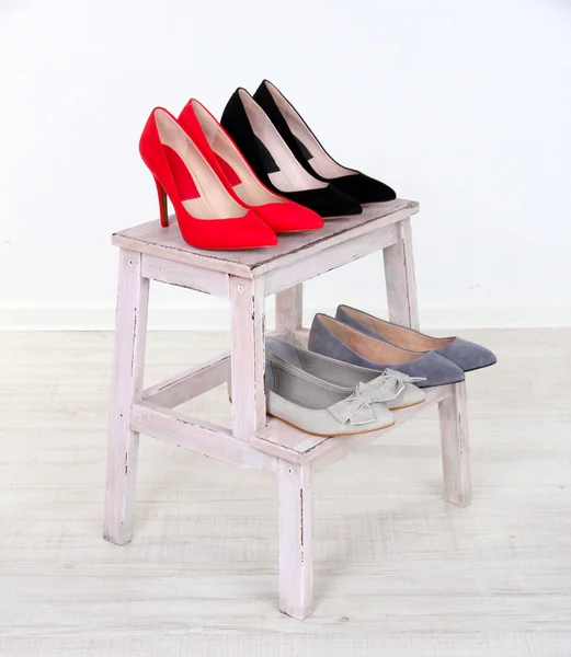 Hermosos zapatos femeninos en estante de madera — Foto de Stock