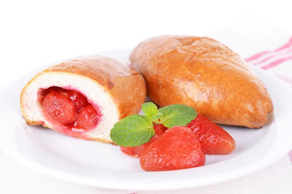 Pasties cozidos no forno frescos com morangos na chapa na mesa close-up — Fotografia de Stock