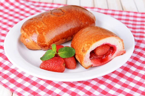 Frisch gebackenes Gebäck mit Erdbeeren auf Teller in Großaufnahme — Stockfoto