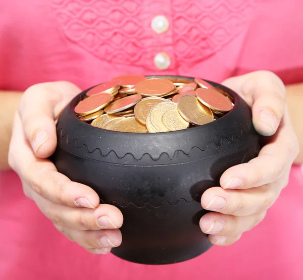 Keramische pot met gouden munten in vrouwelijke handen, geïsoleerd op witte achtergrond — Stockfoto