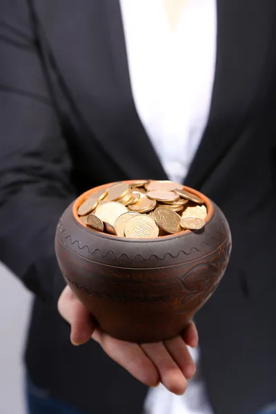 Keramiska potten med gyllene mynt i kvinnliga händer, isolerad på vit bakgrund — Stockfoto