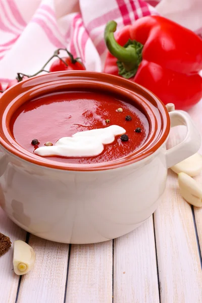 Smakelijke tomatensoep en groenten op houten tafel — Stockfoto