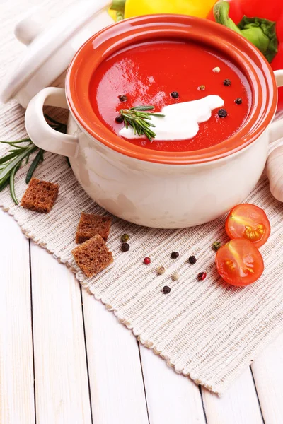 Smakelijke tomatensoep en groenten op houten tafel — Stockfoto