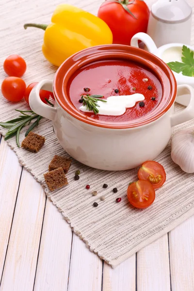 Smakelijke tomatensoep en groenten op houten tafel — Stockfoto