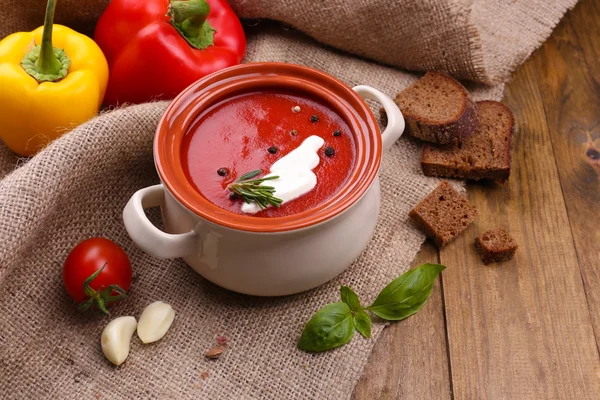 Smakelijke tomatensoep en groenten op houten tafel — Stockfoto