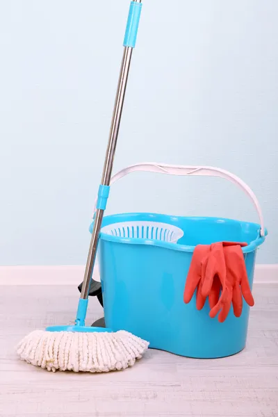 Brosse à plancher et seau pour laver dans la chambre sur fond bleu mur — Photo