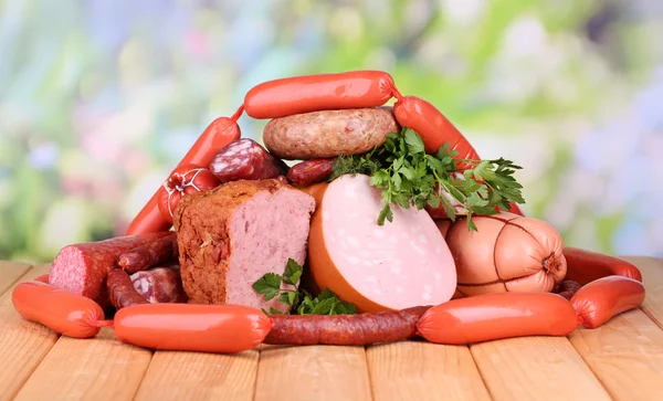 Lote de salsichas diferentes na mesa de madeira no fundo natural — Fotografia de Stock