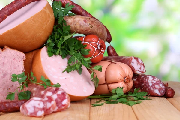 Lote de salsichas diferentes na mesa de madeira no fundo natural — Fotografia de Stock