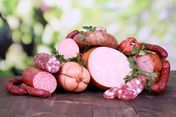 Lote de salsichas diferentes na mesa de madeira no fundo natural — Fotografia de Stock