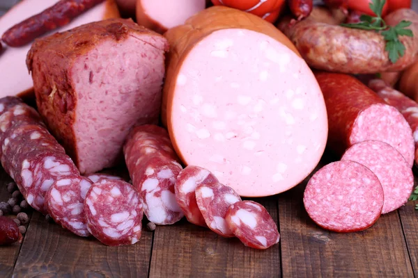 Lot of different sausages on wooden table close-up — Stock Photo, Image
