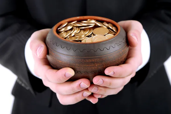 Keramische pot met gouden munten in mannelijke handen, geïsoleerd op witte achtergrond — Stockfoto