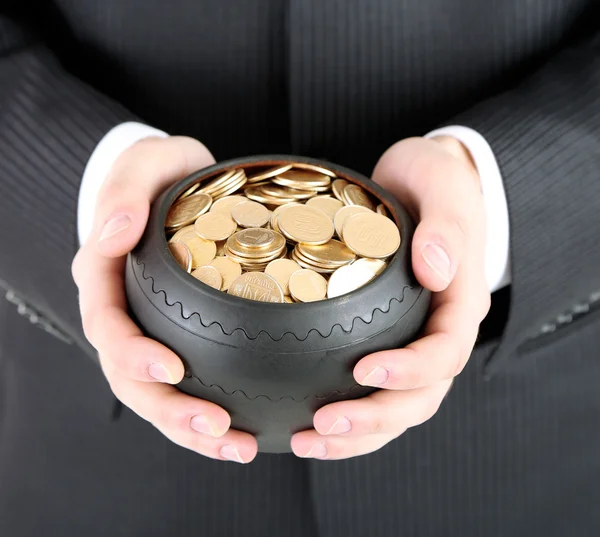 Ceramic pot with golden coins in male hands, isolated on white background — Stock Photo, Image