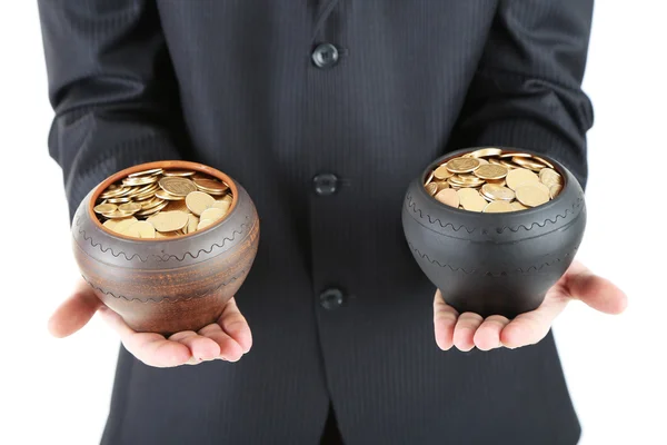 Twee keramische potten met gouden munten in mannelijke handen, geïsoleerd op witte achtergrond — Stockfoto