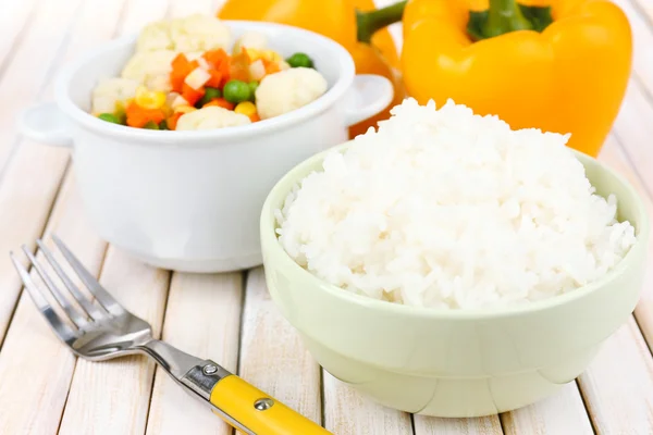 Варёный рис с овощами на деревянном столе — стоковое фото