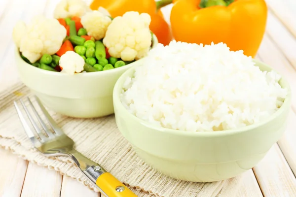 Gekookte rijst met groenten op houten tafel close-up — Stockfoto