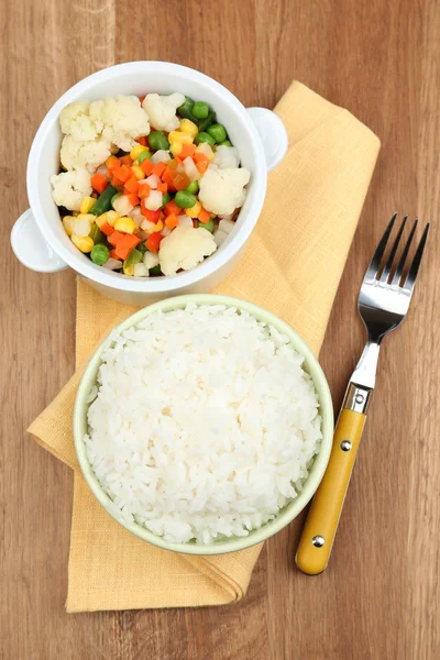 Gekookte rijst met groenten op houten tafel — Stockfoto