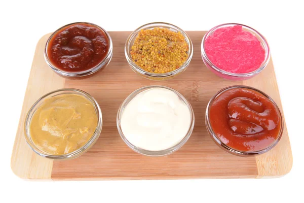 Various sauces on chopping board isolated on white — Stock Photo, Image