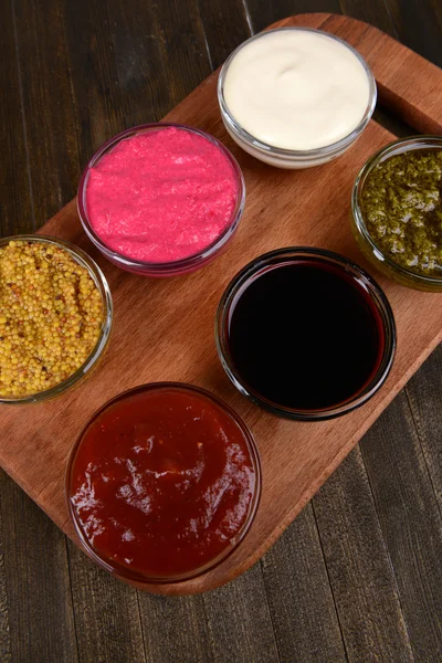 Various sauces on chopping board on table close-up — Stock Photo, Image