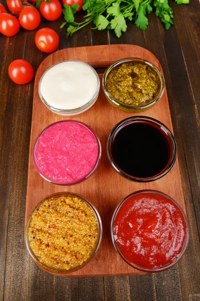 Verschiedene Saucen auf Schneidebrett auf dem Tisch in Großaufnahme — Stockfoto