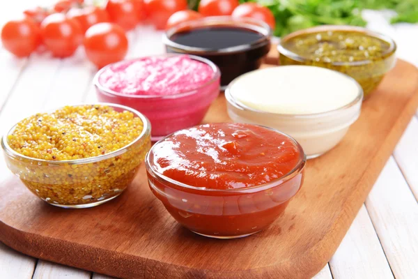 Various sauces on chopping board on table close-up — Stock Photo, Image