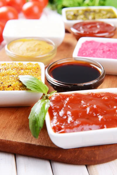 Various sauces on chopping board on table close-up — Stock Photo, Image