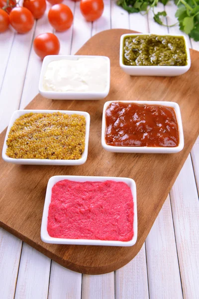 Various sauces on chopping board on table close-up — Stock Photo, Image