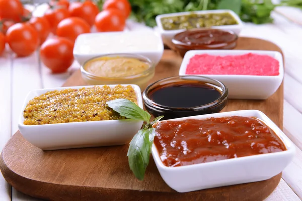 Various sauces on chopping board on table close-up — Stock Photo, Image