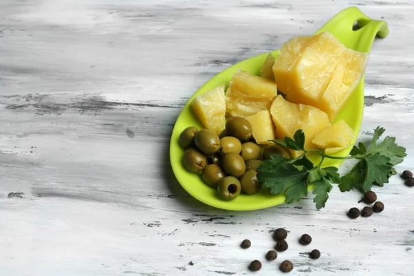Sýr parmezán, čerstvé bylinky a olivy na dřevěné pozadí — Stock fotografie