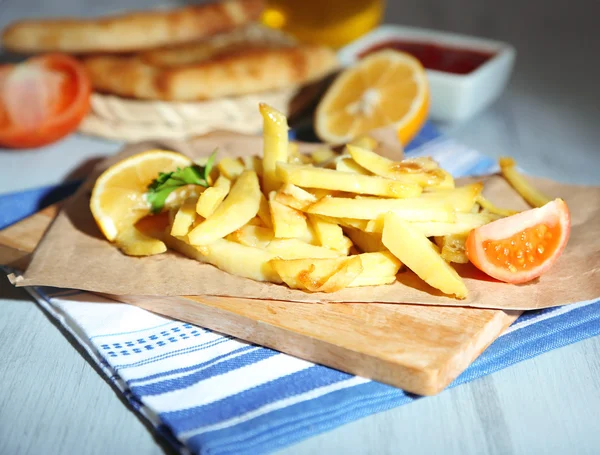 Ruddy fritou batatas na tábua de madeira na mesa close-up — Fotografia de Stock