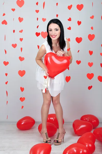 Attraktive junge Frau mit Luftballons im Zimmer am Valentinstag — Stockfoto