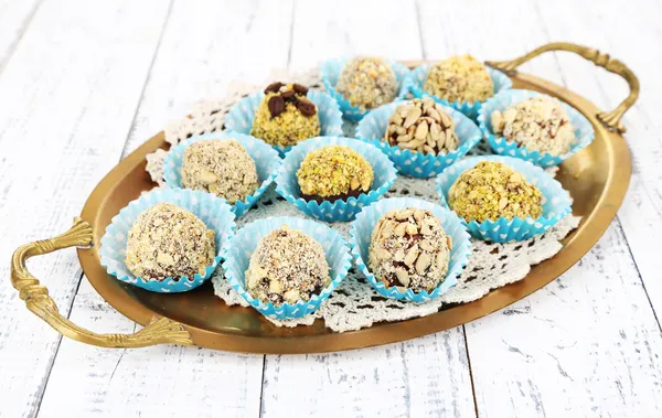 Conjunto de bombones de chocolate, en bandeja, sobre fondo de madera de color — Foto de Stock