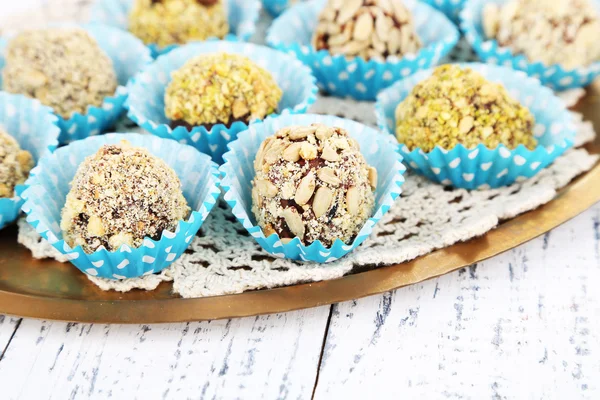 Set van chocolade snoepjes, op het dienblad, op een houten achtergrond kleur — Stockfoto