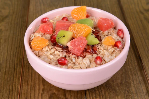 Deliciosa harina de avena con fruta en tazón en primer plano de la mesa —  Fotos de Stock