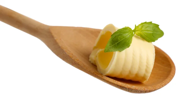 Curl of fresh butter with basil on wooden spoon, isolated on white — Stock Photo, Image