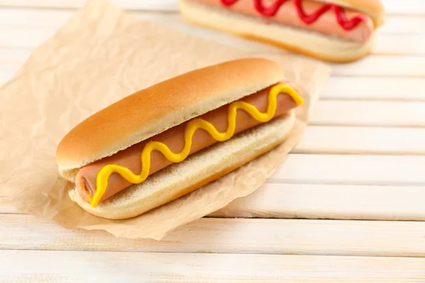 Pyszne hot dogi na drewnianym stole — Zdjęcie stockowe