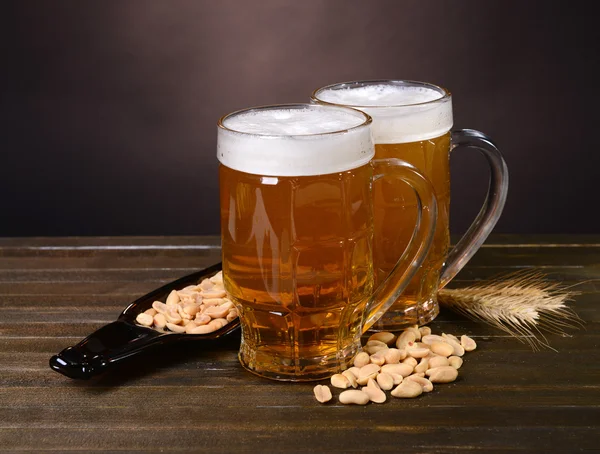 Bicchieri di birra con spuntino sul tavolo su sfondo scuro — Foto Stock