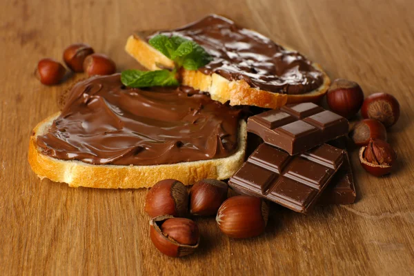 A mogyorós csokoládé terjed a fa háttér édes kenyér — Stock Fotó