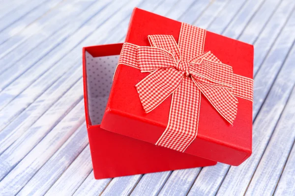 Open gift box on wooden background — Stock Photo, Image
