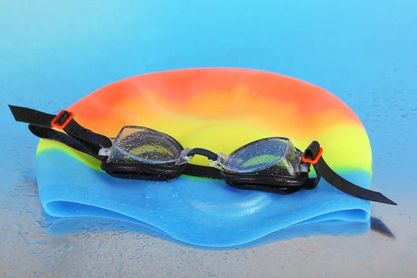 Swim cap and goggles on silver background — Stock Photo, Image
