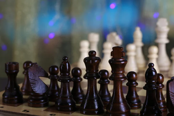 Peças de xadrez a bordo em fundo brilhante — Fotografia de Stock