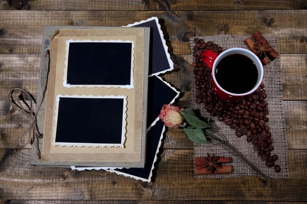 Sammansättning med kaffe kopp och foto album, på trä bakgrund — Stockfoto