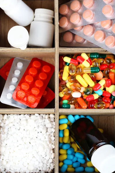 Medical pills, ampules in wooden box, close-up — Stock Photo, Image