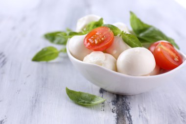 kase, ahşap masa üstünde domates ve fesleğen ile lezzetli mozzarella peyniri