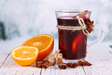 Baharatlı ve portakallı sıcak şarap parlak arka planda.