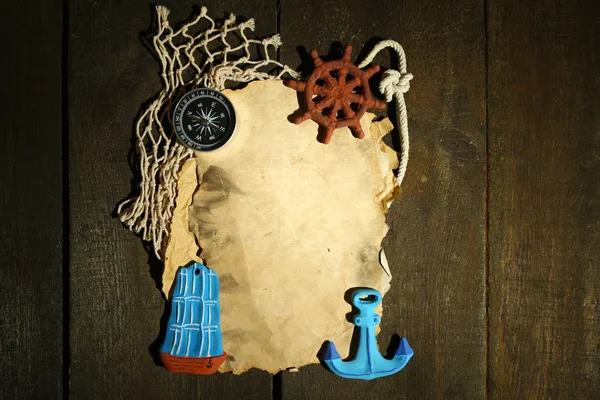 Oud papier met zee accessoires, geïsoleerd op houten achtergrond — Stockfoto