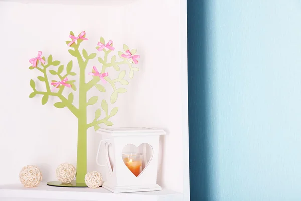 Árbol decorativo con arcos, en estante, sobre fondo de pared azul —  Fotos de Stock