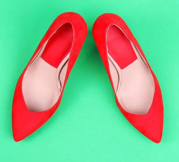 Yeşil zemin üzerine güzel kırmızı kadın ayakkabı — Stok fotoğraf